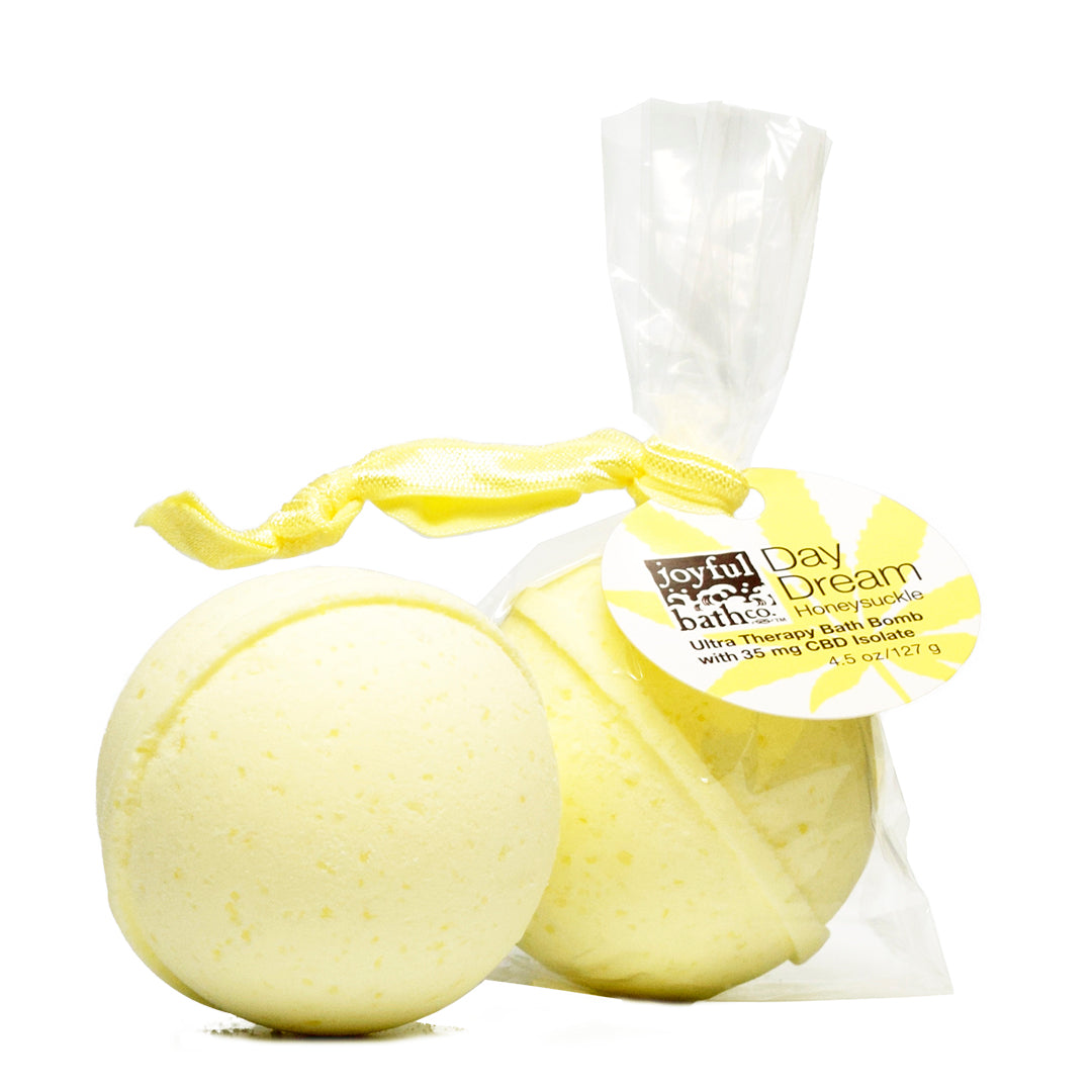 Day Dream Honeysuckle Hemp Bath Bomb with a yellow hairtie over a white background
