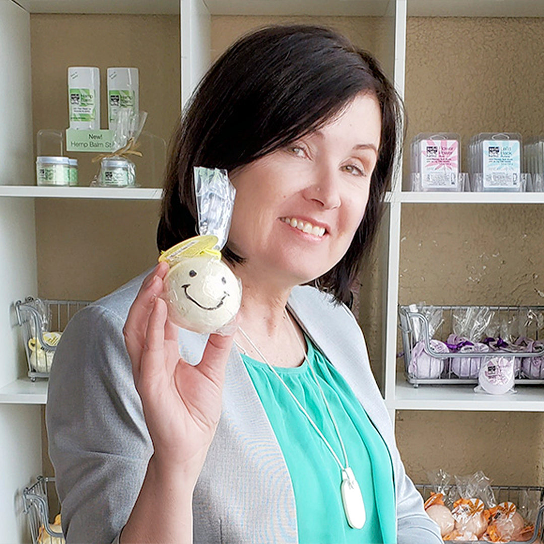 CEO Rochel Roland holding a bath bomb with a smiley face