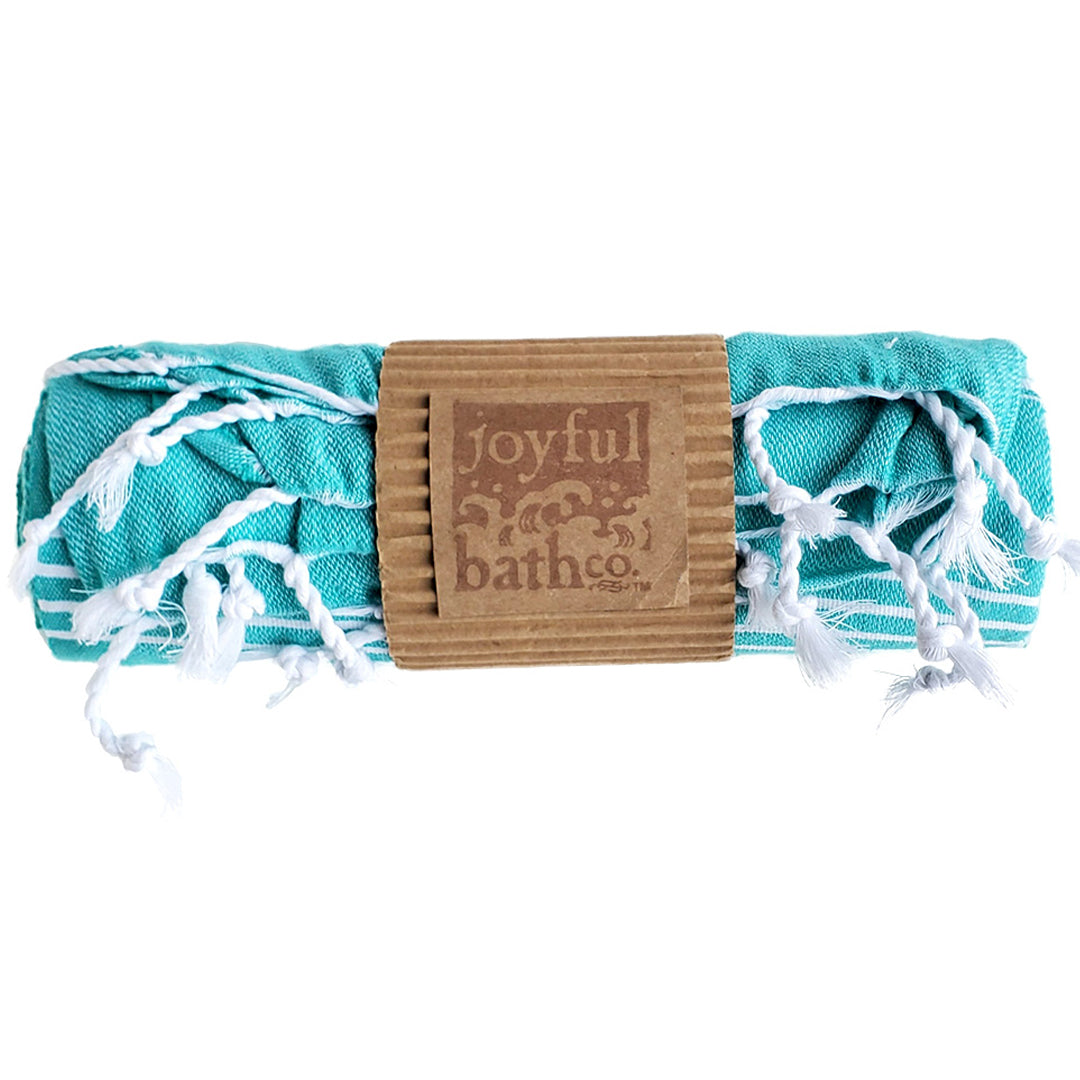 Turkish Towel in teal all rolled up with a kraft paper  and stamped logo