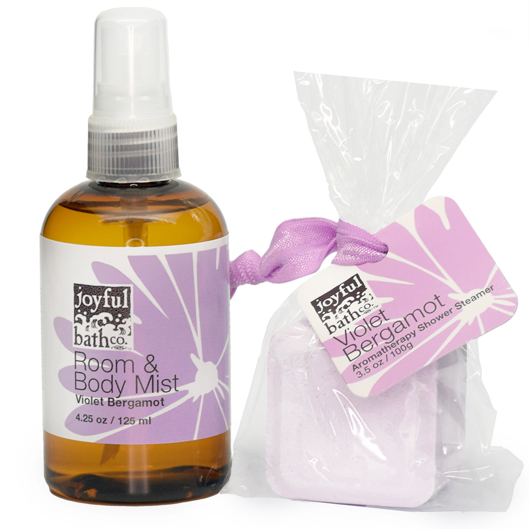 side by side bottle of Room and Body Mist next to a shower steamer in the scent Violet Bergamot