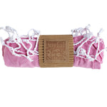 Turkish Towel in Pink rolled up with a kraft paper wrap and a stamped logo