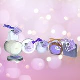 Bokeh image of the Total Bliss Contents Soy Candle, Shower Steamer, Bath Bomb, Bubble  Bath Scoop and Soap with a slight purple background